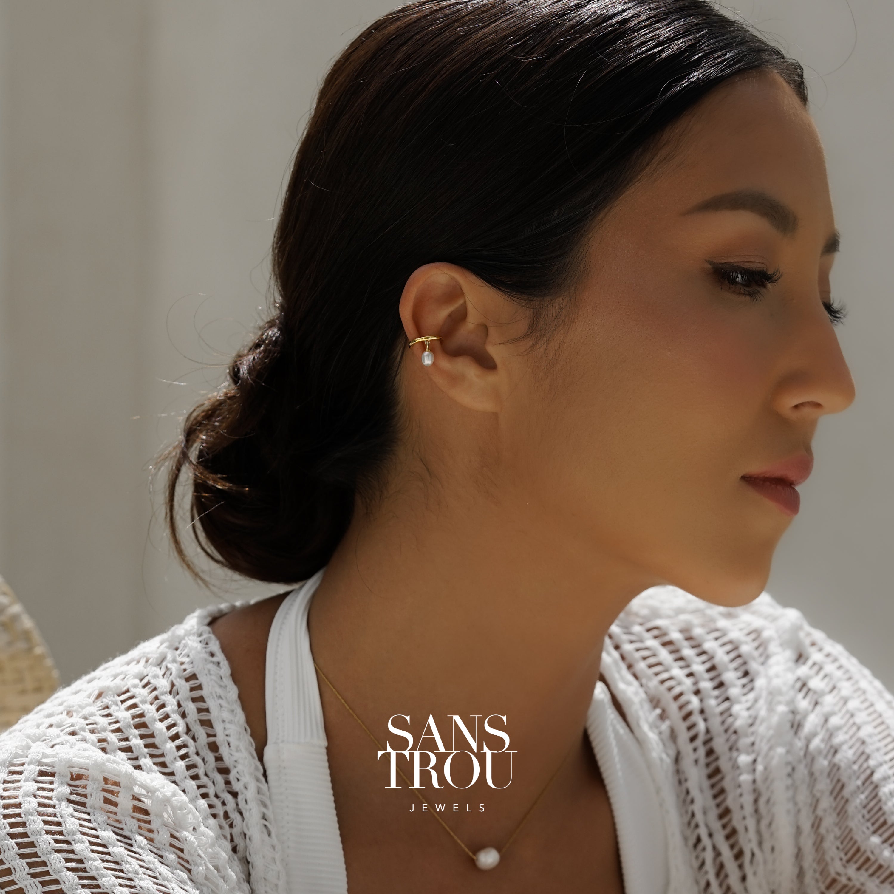 Ear cuff with dainty dangle freshwater pearl worn on an ear. Branded SANS TROU