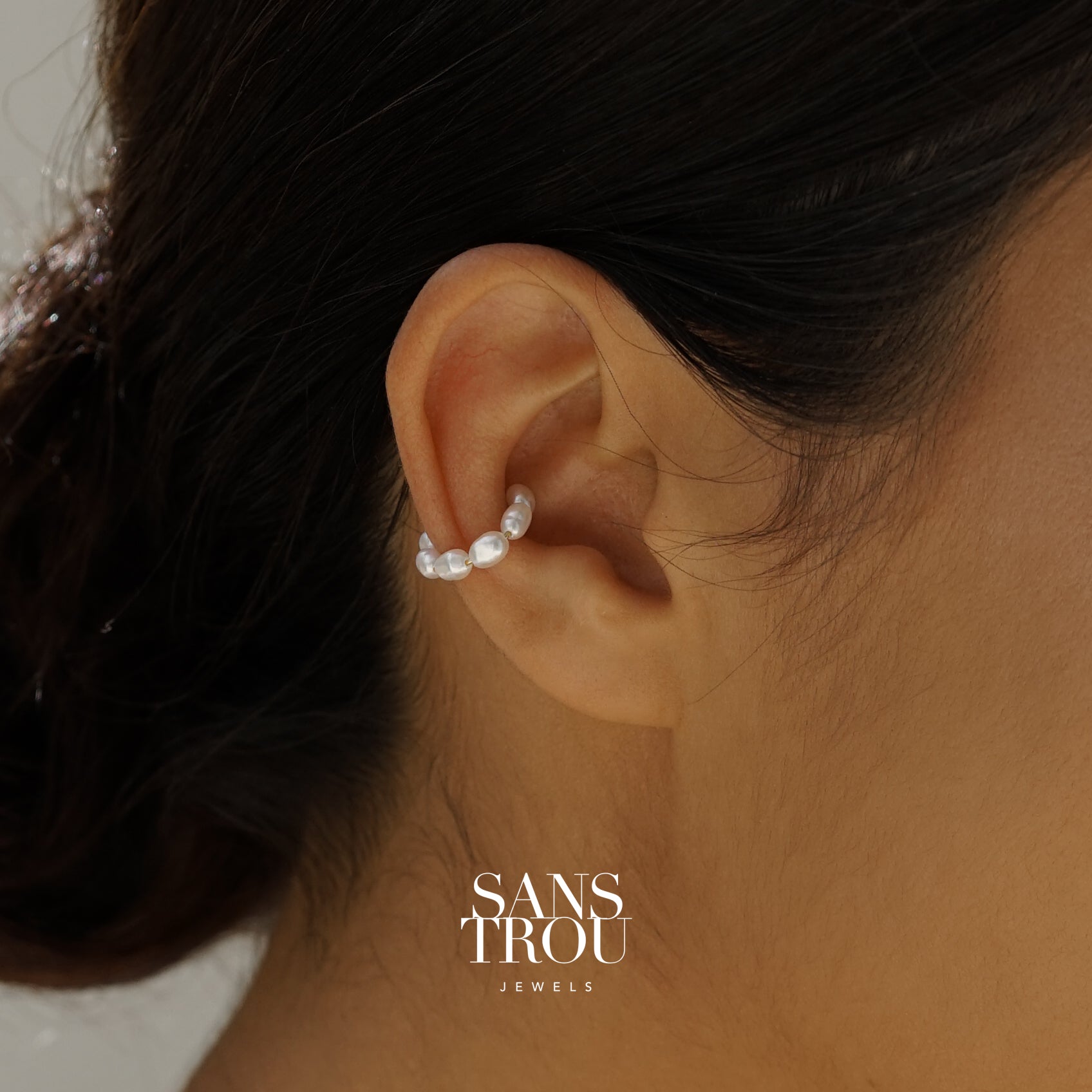 Close-up of an ear wearing a freshwater pearl ear cuff 