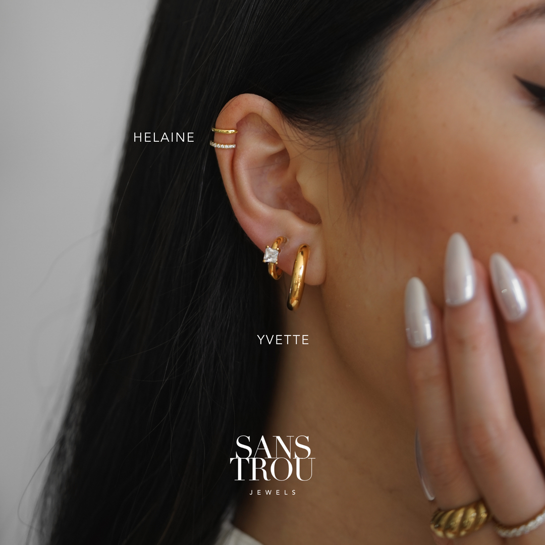 Close-up of an ear wearing gold clip-on earring hoop earrings with a helix ear cuff