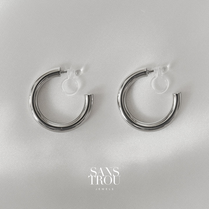 Sans Trou classic silver hoops made with high polish stainless steel.  The Alia features a resin clip attachment.