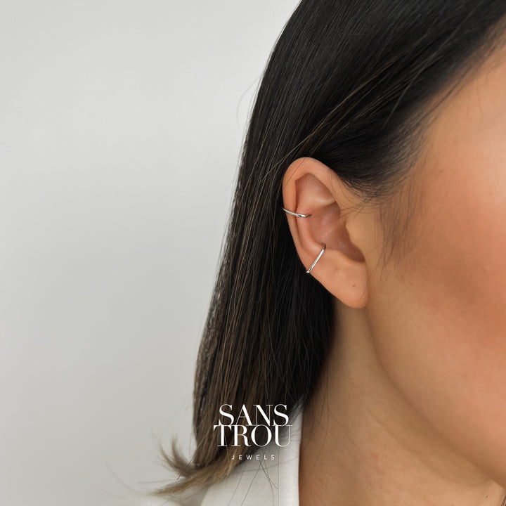 Model wears a silver ear cuff set with a rectangular slim design. The cuff set is worn as a conch and helix piercing. 