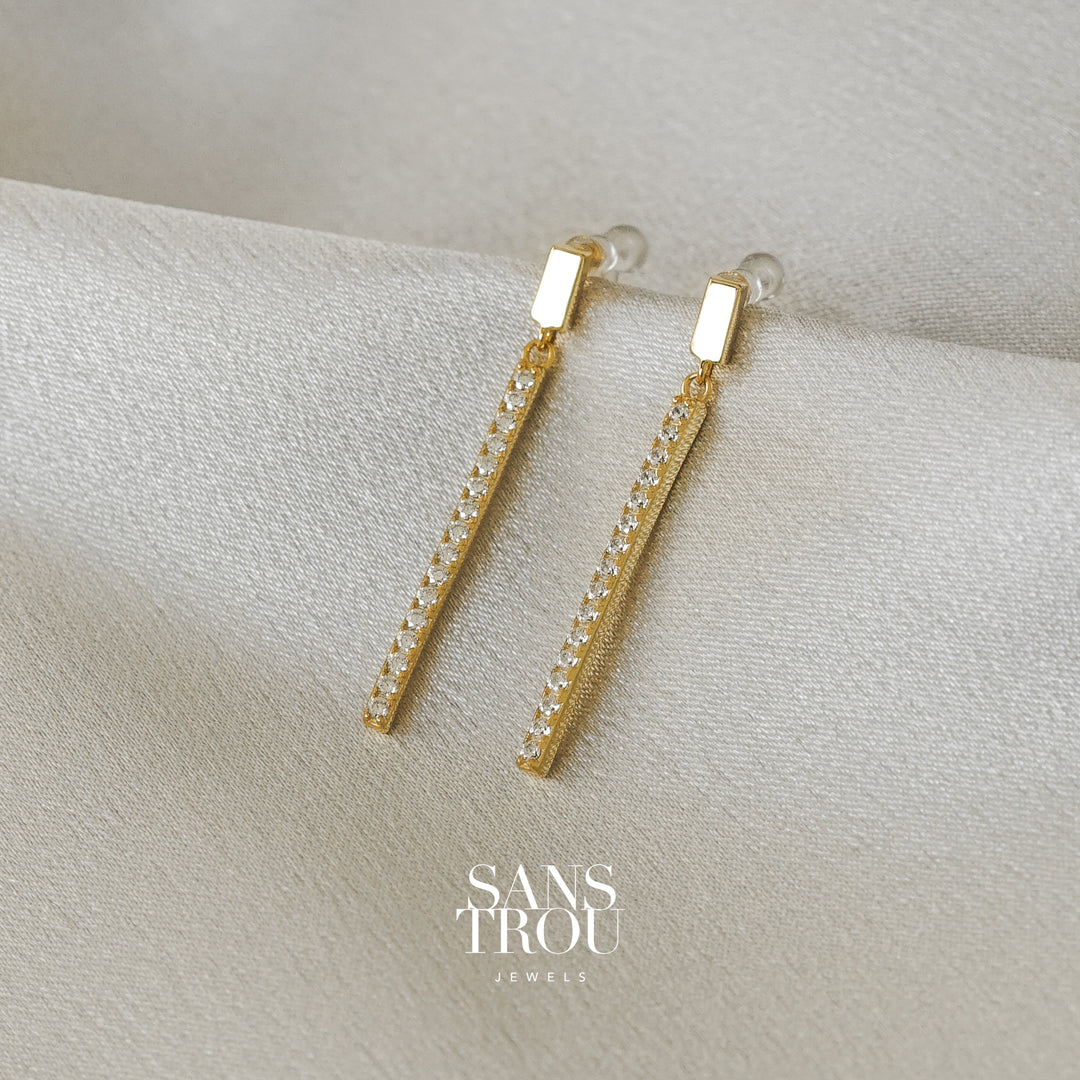 Sans Trou 18k gold plated drop clip-on earrings featuring a line sterling silver bar with CZ stones.     