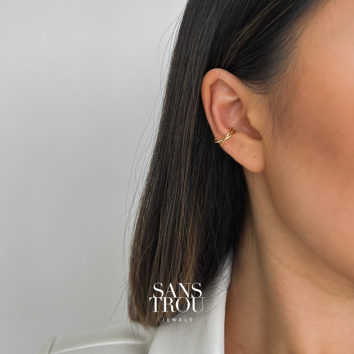 Model wears a 18k gold plated criss cross style ear cuff as a conch piercing. 