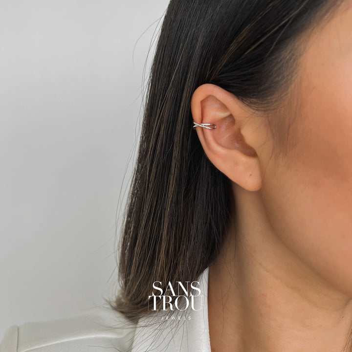 Model wears a sterling silver criss cross style ear cuff as a helix piercing.