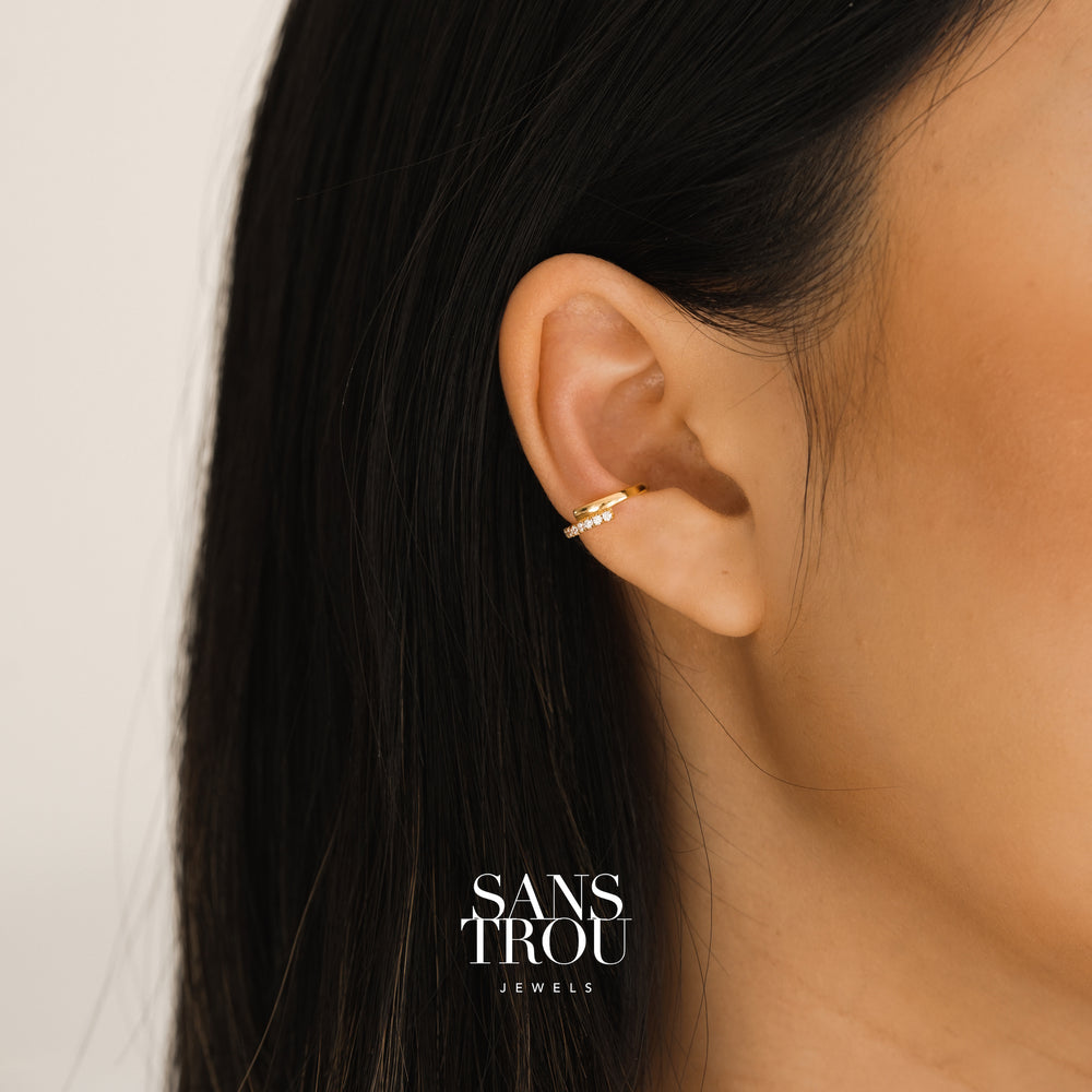 Model wears 18k gold plated ear cuff with a soft Z shape design. The ear cuff features CZ stones and is worn on the conch 