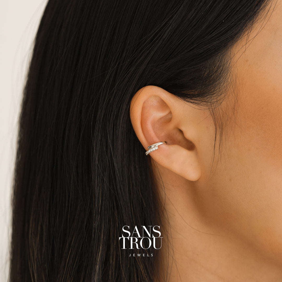 Model wears sterling silver ear cuff with a soft Z shape design. The ear cuff features CZ stones and is worn on the conch 