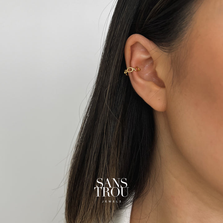 Model wears 18k gold plated ear cuff with a dainty rounded chain style on the cartilage.