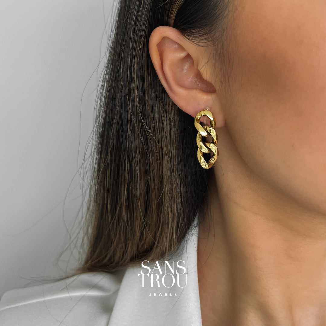 Model wears the 18k gold plated clip-on earring with a drop chain style on the lobe. 