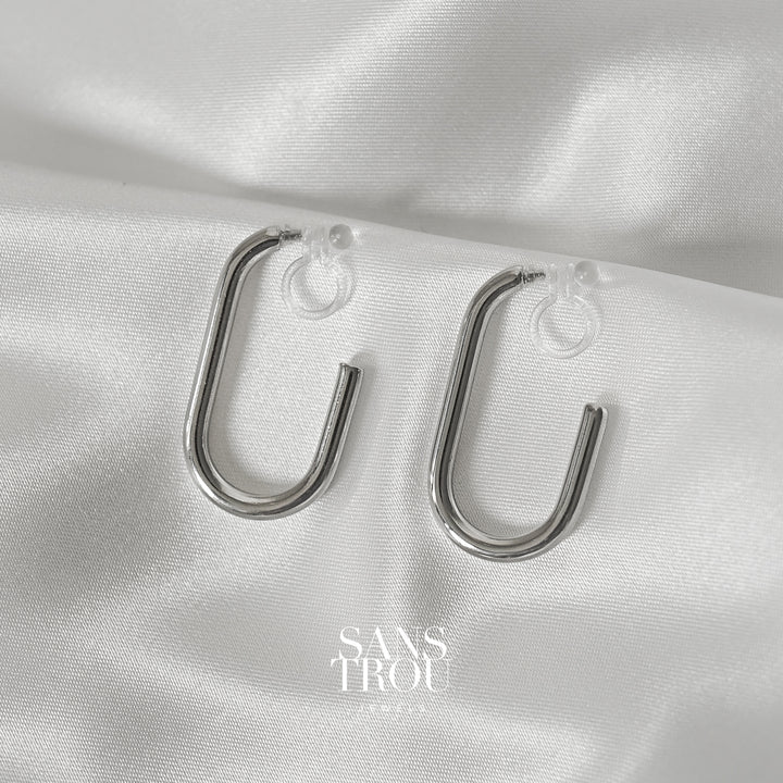 Elle clip-on hoop earrings in silver by SANS TROU. Rounded rectangular clip-on earring with clear resin clip. No piercings need. Piercing-free jewellery.
