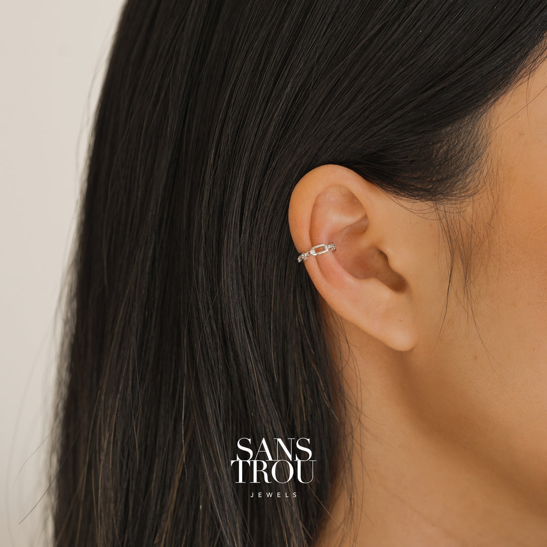 Model wears dainty silver chain ear cuff with CZ stones on the cartilage. 