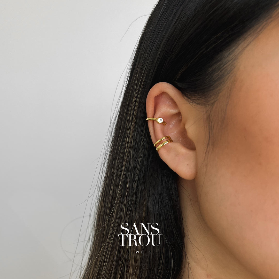 Model wears 18k gold plated ear cuff set. The double layered cuff is positioned on the conch and CZ stone cuff can be worn on the helix.  
