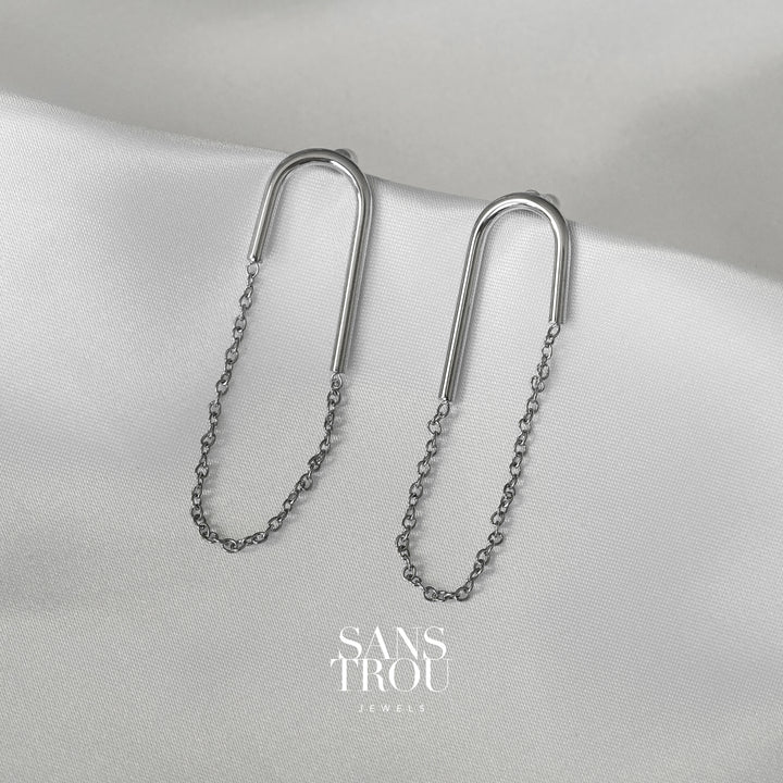 Sans Trou silver U shaped clip-on earring with an attached drop chain. The Lea is worn on the lobe and has an asymmetrical pair. 