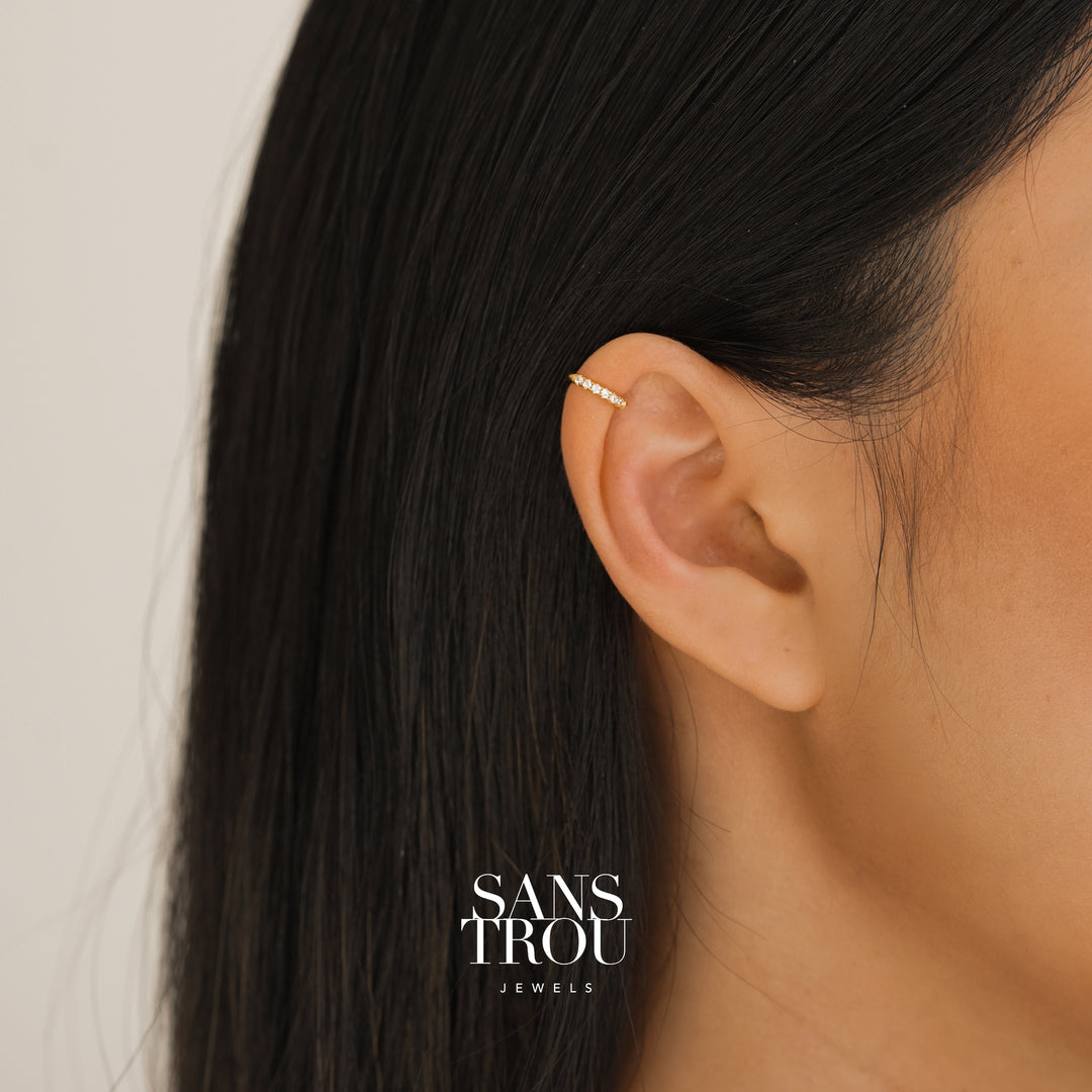 Model wears dainty ear cuff with 18k gold plating and CZ stones on the helix. 