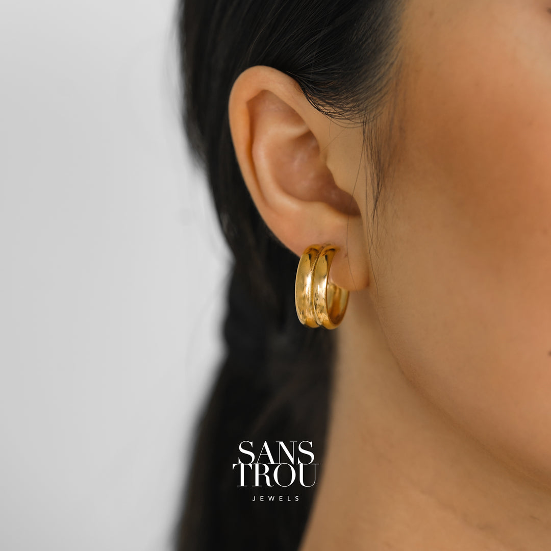 Model wears a 18k gold plated clip-on hoop earring featuring a double banded hoop. 