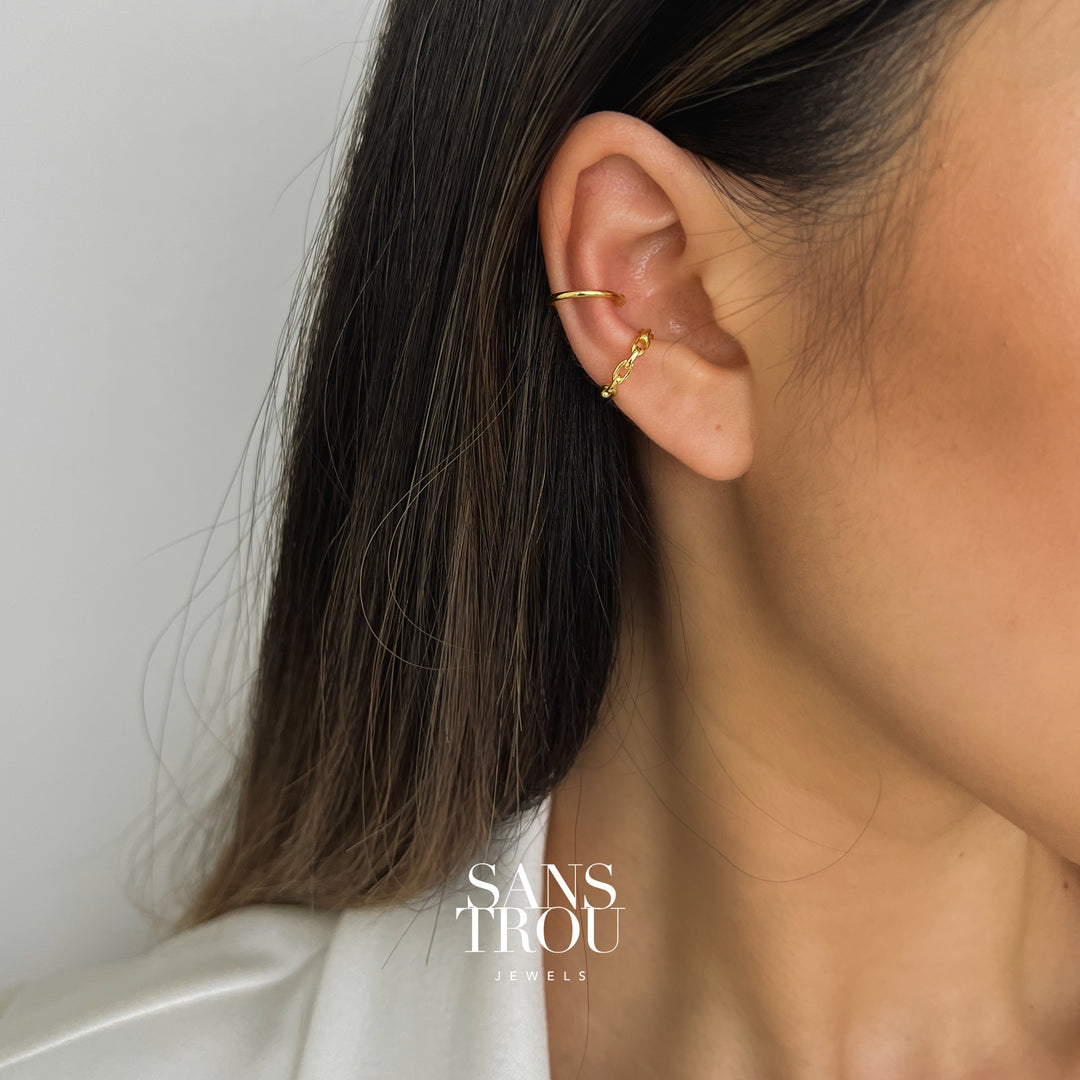 Model wears the gold banded and rounded circle chain cuff ear cuff on the helix and conch.  
