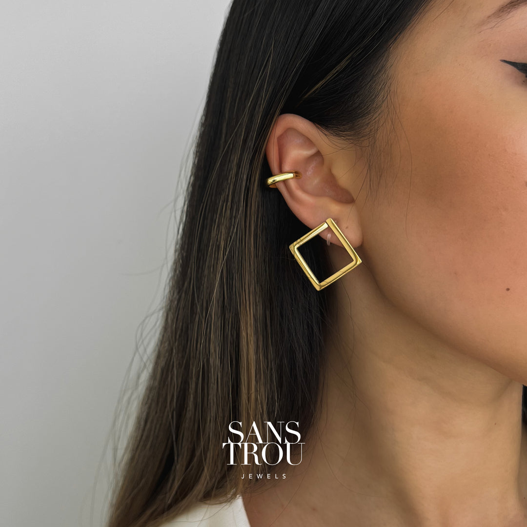 Model wears a 18k gold plated square clip-on earring on the lobe. The Sara is attached by a hidden resin clip. 