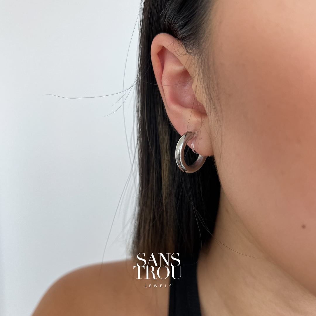 Model wears stainless steel silver clip-on hoop earring on the lobe. The Yvette is attached to the ear by a resin clip. 